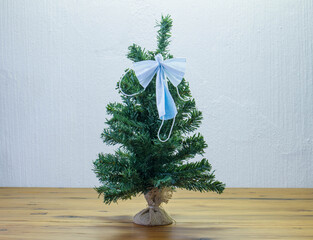 An angel made from covid-19 facemasks attached to the top of a Christmas tree