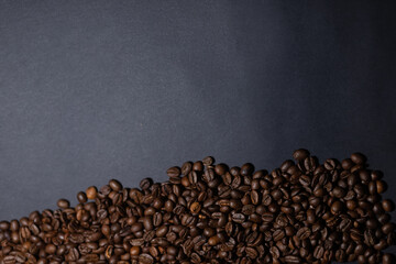 heap of coffee beans on black background. Coffee beans pile isolated on black background. Culinary coffee background.