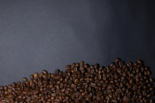 heap of coffee beans on black background. Coffee beans pile isolated on black background. Culinary coffee background. © Misha