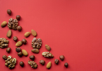 Nuts scattered flat lay on red background