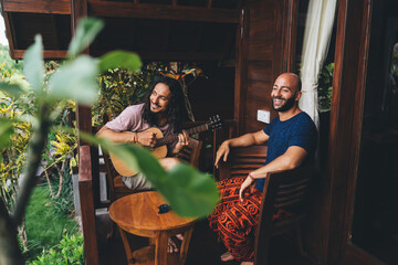 Happy multiethnic friends playing guitar