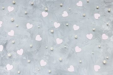 Romantic gray backround with pastel pink paper hearts and white pearls. Love, dating and Valentines Day concept, copy space