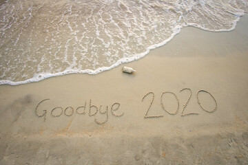 Fototapeta premium Goodbye 2020 inscription written on the sandy beach. New year conceptual.