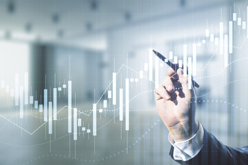 Multi exposure of analyst hand with pen working with virtual abstract financial diagram on blurred office background, banking and accounting concept