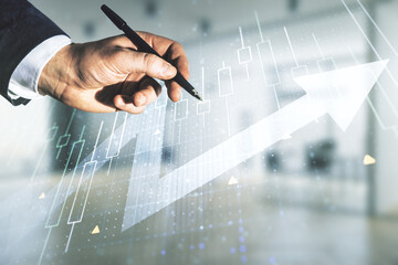 Double exposure of man hand with pen working with abstract creative financial diagram and upward arrow on blurred office background, growth and development concept