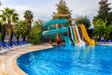 Swimming pool with water slide at the tropic summer resort