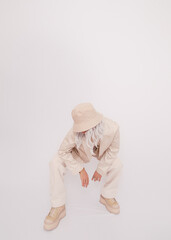 Urban street style Girl in white studio. Details of everyday look. Casual beige outfit and...