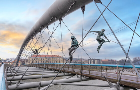 KRAKOW, POLAND - April 3, 2019: Krakow's Father Bernatek footbridge with acrobatic figures statues by Polish artist Jerzy Jotki Kedziora.