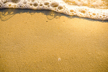 Close up of soft wave at seaside with natural sunset lighting.