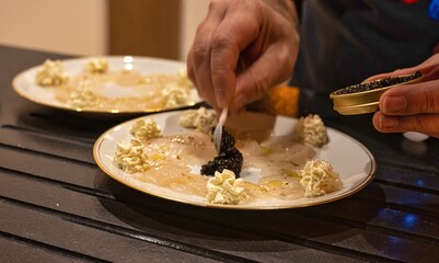 Préparation en cuisine du Carpaccio de saint Jacques et caviar
