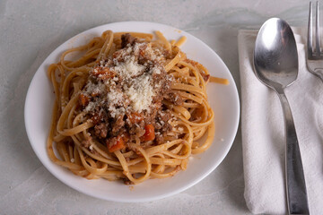 White Plate of Pasta alla Bolognese with Meat Sauce, Cheese and Vegetables