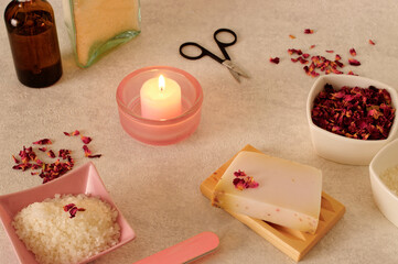 Natural cosmetics on bright background. Rose soap, bath salt and candles. Romantic bathing arrangement.