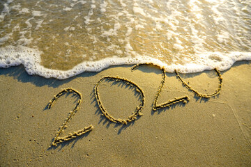 Goodbye year 2020 written on the sandy beach. 
