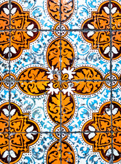 Portuguese traditional tiles Azulejos with blue and orange floral pattern on a white background.