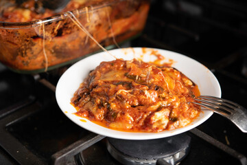 Baked Eggplant Parmagiana From Oven With Red Sauce and Cheese Being Served on White Plate