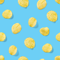 Seamless pattern made from Potato chips on light blue background flat lay. potato snack chips...