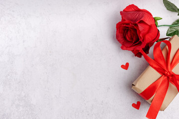 Valentines concept with flower red rose and wrapped gift box on a gray background. copy space