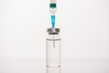 SarsCov-2 vaccination concept. Cropped close up view photo of vial with transparent liquid and syringe with needle isolated white background