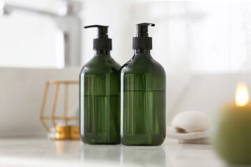 Green soap dispensers on white countertop in bathroom