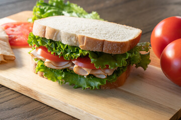Turkey, lettuce and tomato sandwich on cutting board