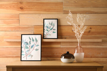 Decorative vases and pictures on wooden table