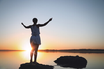 Fototapeta premium Woman near river on sunset. Healing concept
