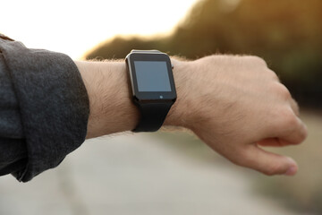 Man with smart watch outdoors, closeup view
