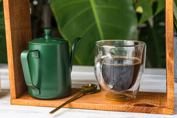 Green kettle Fragrant coffee drip set on an old wooden table