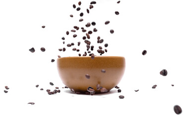Flying coffee beans into a brown bowl on a white background, close-up. Blurred. Selective focus. Dynamic composition