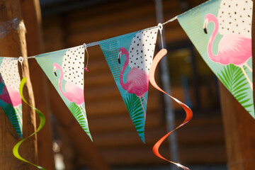 Decorative paper flags with flamingo illustrations for theme Hawaii birthday party or outdoors festive event. © Olena Seiryk