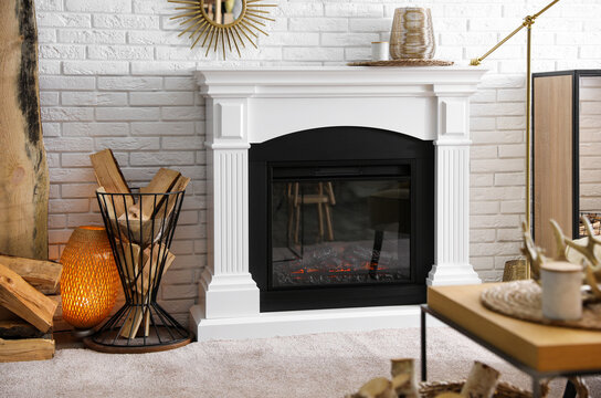 Firewood In Holder Near Modern Fireplace In Living Room