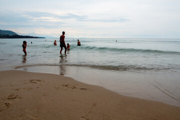 Naklejka premium People swimming in calm Mediterranean sea in Sicily (Italy) at sunset