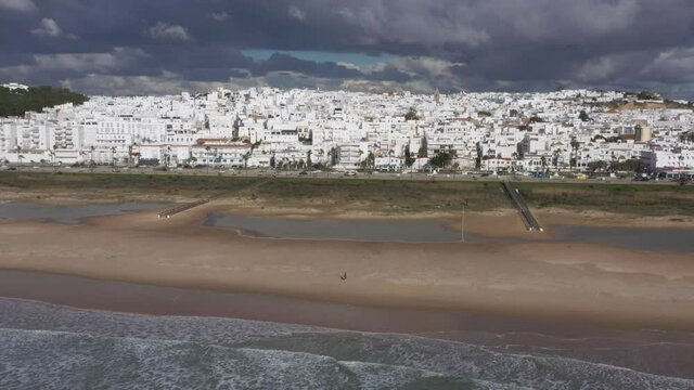 Los Bateles beach with paseo maritimo in winter seen from above aerial view of white coast town in Andalusia at the Atlantic Ocean