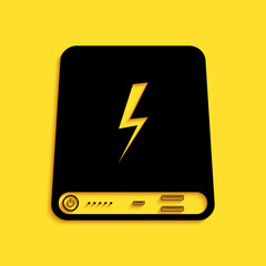 Black Power bank icon isolated on yellow background. Portable charging device. Long shadow style. Vector.