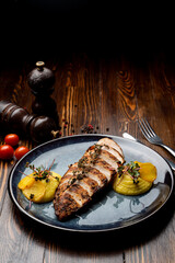 Grilled chicken breast with mashed potatoes, clay blue dish, dark wooden table