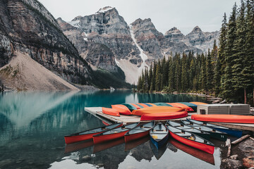 Canoes on a jetty on the turquoise waters of Moraine Lake, located in Banff National Park, Alberta, Canada, situated in the Valley of the Ten Peaks. The peaks are known as the "Twenty Dollar View".