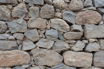 antique masonry made of hewn stones of gray-brown color and different shapes