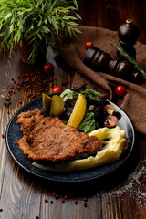 Austrian schnitzel with pickles and potato in a restaurant, top view