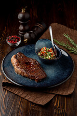 Juicy sirloin grilled and served with salad, dark restaurant photo