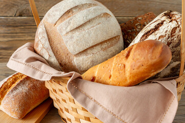 Composition of various baked products in basket on rustic background. Homemade fresh pastry.