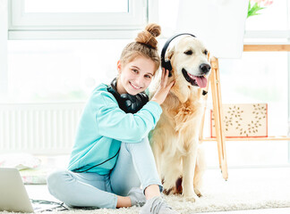 Happy girl with dog in headphones