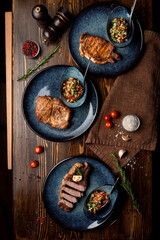 Obraz na płótnie Canvas Assortment of juicy appetizing steaks on a wooden table of a fancy restaurant