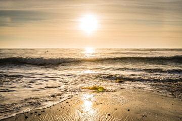 sunset over the ocean on a sandy beach