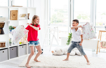 Laughing kids having fun while pillow fight