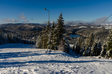 Beautiful panoramic view over the "Marisel" ski slope in winter season and Belis lake in the valley, Cluj county Romania.