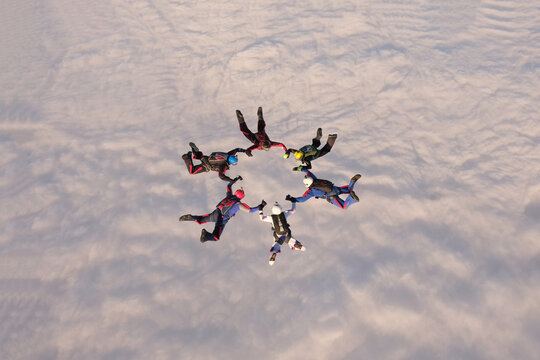 Skydiving. A team of skydivers is doing a figure in the sky. Group jump.