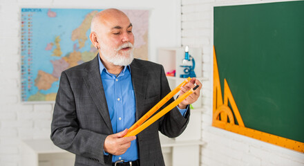 Senior intelligent man teacher at chalkboard. Education goals. School education concept. Useful...