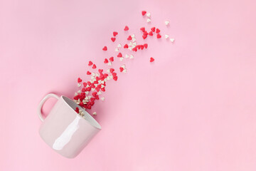 Mug with sugar hearts on pink background