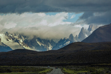 Asphalted road with the peaks of a rocky and snowy mountain on the horizon. Fitz Roy mountain in Argentina Horizontal Photograph