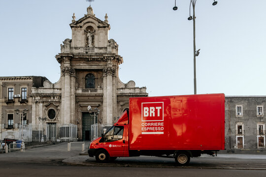 Catania, Italy - 27 dec 2020 - BRT corriere espresso branded express courier truck on the Piazza Carlo Alberto square, in front of the Madonna del Carmelo baroque church. Illustrative editorial.